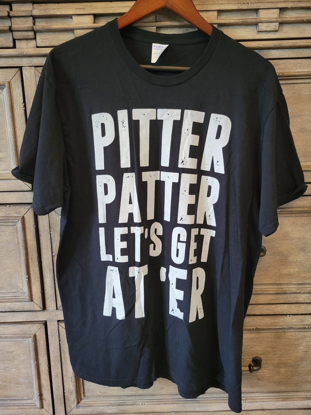 Port and Company Black T‑Shirt with White Text "Pitter Patter Let's Get At 'Er"